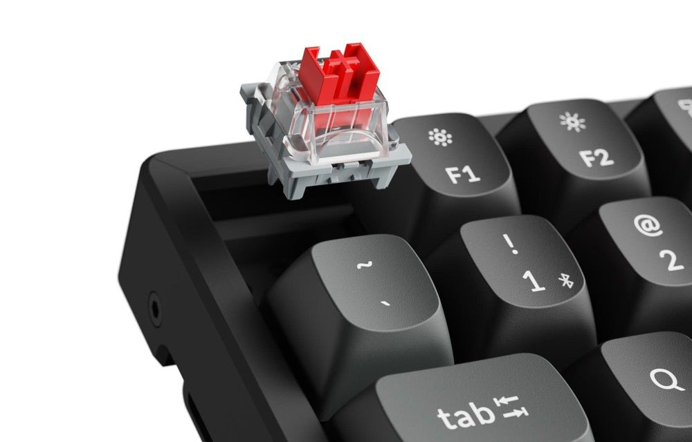 Switch Keychron Apex Red sollevato dallo zoccolo hot-swap della K8 Ultra 8K, accanto ai keycap PBT double-shot